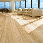 Polished oak solid wood flooring in a cozy living room with natural sunlight.