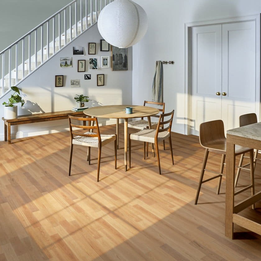 Bright Scandinavian dining area with warm wood effect laminate flooring