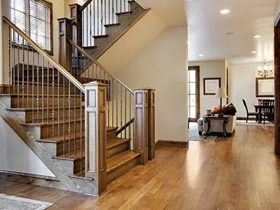 Home entryway with oak hardwood flooring and staircase with metal balusters