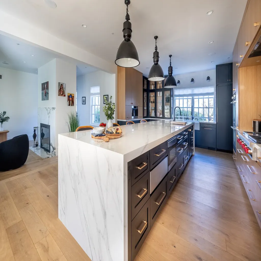 Villa Renovation 9 modern-villa-kitchen-marble-island-navy-cabinets-brass-hardware-pendant-lights