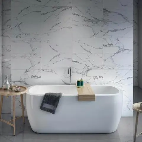 freestanding-white-bath-with-wooden-caddy-against-large-format-marble-effect-wall-tiles