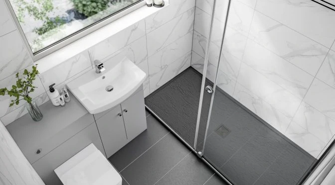 modern compact bathroom with marble wall tiles dark slate shower tray glass shower enclosure and white vanity unit